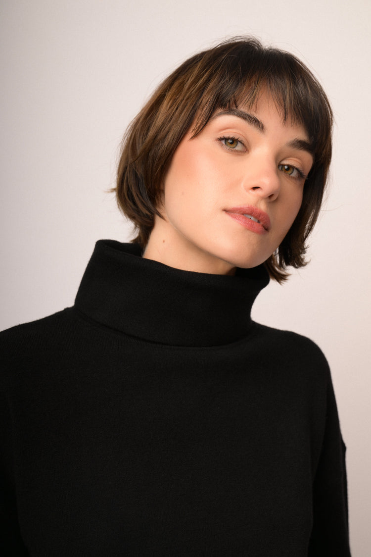 Maglia nera a collo alto con maniche ampie